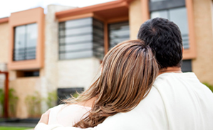 A couple standing outside of their condo. 