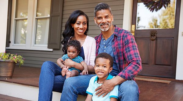 Family sitting on the front stairs of a home.  
