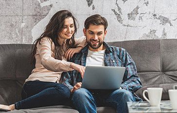 Man looking at a laptop with woman pointing at screen. 