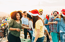 Group of people smiling and laughing during a holiday party.