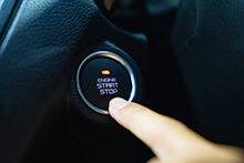 Engine start button being pressed by finger.