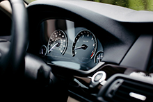 Modern car dashboard with speedometer and tachometer.