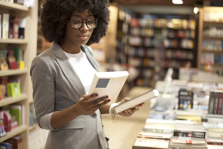 A woman in a book store looking at a specific book.