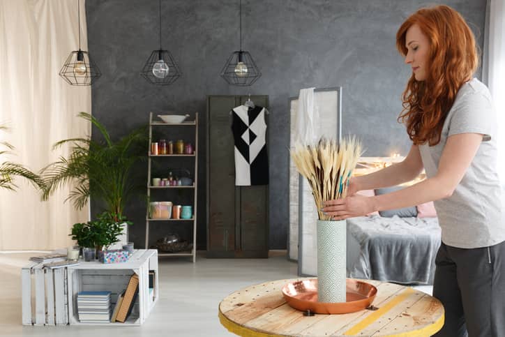 Woman decorating a room in a apartment.