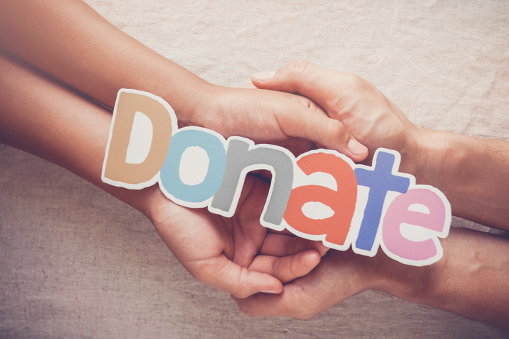 Hands holding the word Donate. 