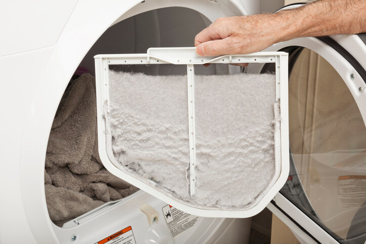 Man holding a dryer's full lint tray.