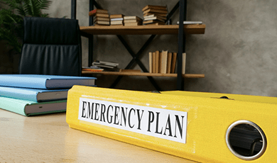 Large yellow binder book, titled Emergency plan on the spine.