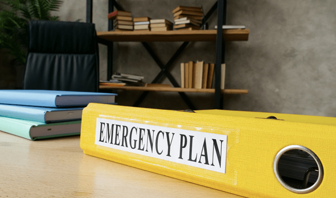 Large yellow binder book, titled Emergency plan on the spine.