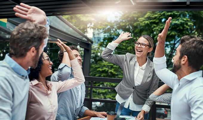 Employees celebrating with a group high-five.