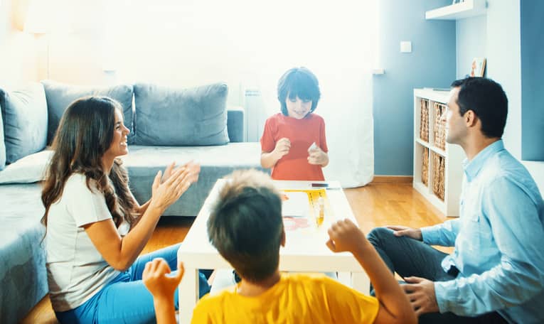 Family in the living room playing a board game. 