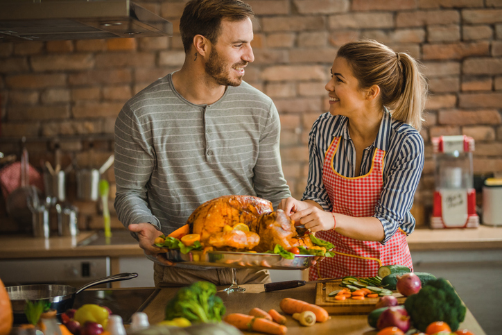 A couple preparing a thanksgiving turkey.