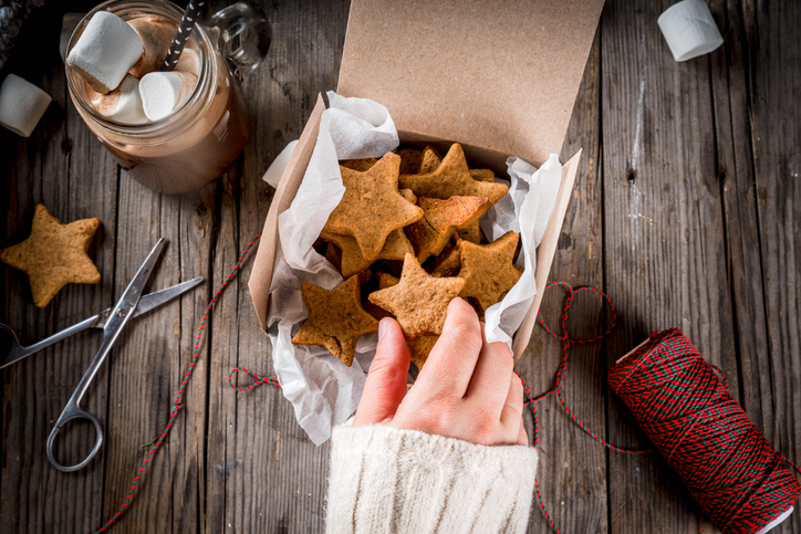 Christmas cookies being packaged and a jar of hot chocolate.