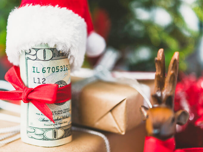 Cash rolled up with a santa hat on top.