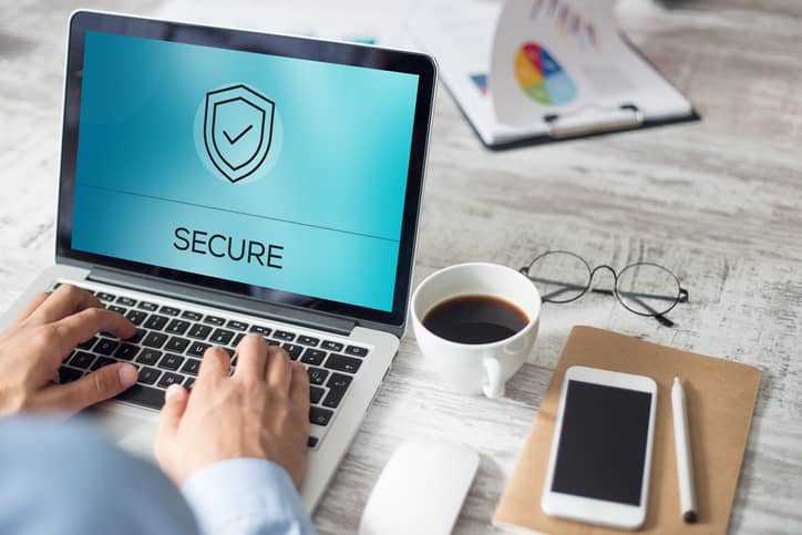 A man on his laptop with screen displaying the word secured.