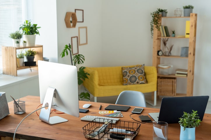 A view of a home-based office with desktop monitor and laptop on the desk.