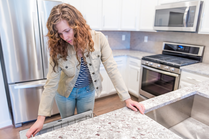 A woman inspecting the kitchen.