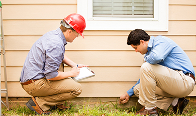 adult male with clipboard inspects vinyl siding. 