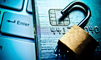 A open padlock, credit card and laptop. 