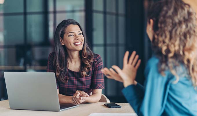 two women meeting with each other in a office.