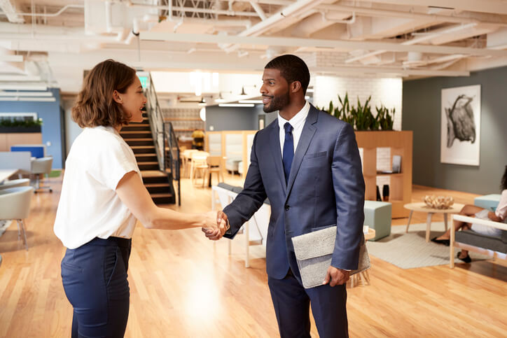 Woman shaking hands with a man in the office.