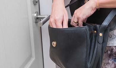 Women searching her purse near a locked door.