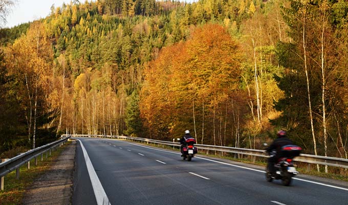 Two riders on their motorcycles riding highway road.