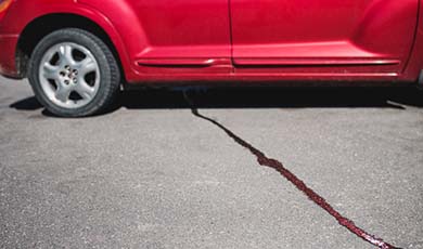 Oil streak on driveway coming from car.