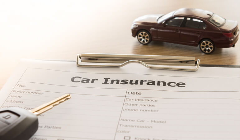 Key on top of insurance paperwork.