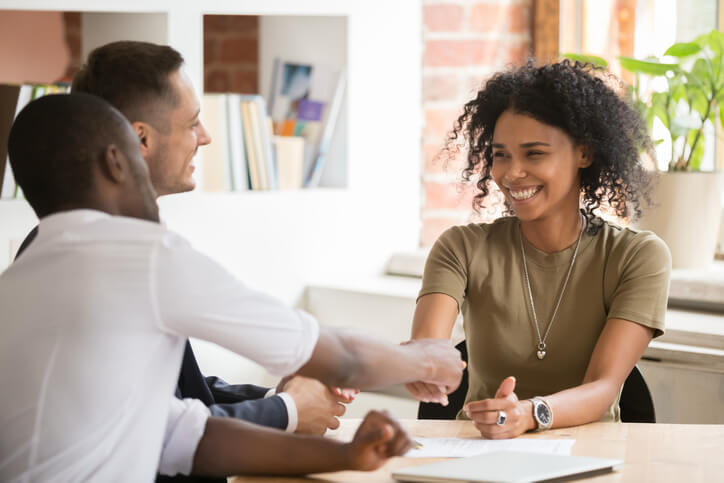 Gentleman shaking hands with a woman in an office.