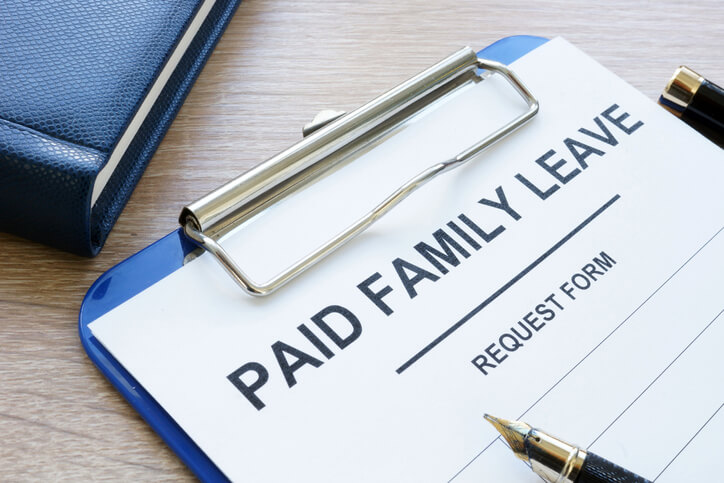 A clipboard with a paper titled paid family leave.