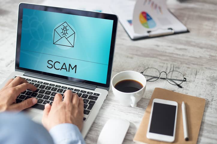 A man looking at phishing scam computer screen.