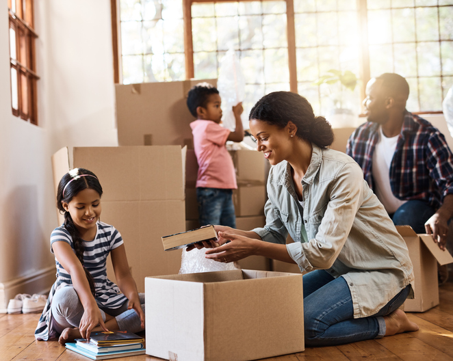 A family packing their valuables in moving boxes.