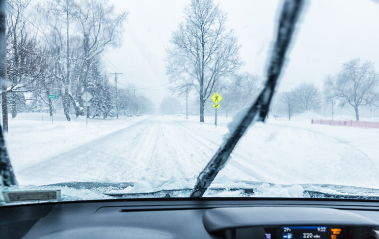 Windsheild wipers clearing snow away from the window.