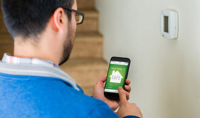 Man arming his home security through his smartphone.