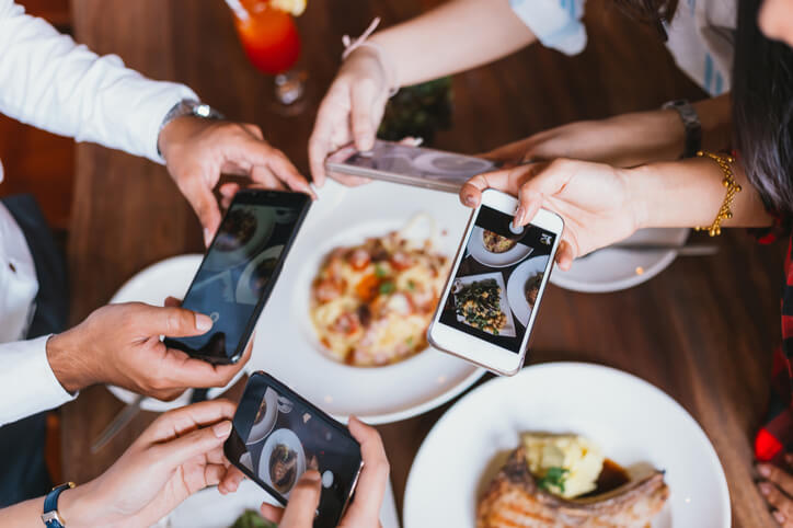 Group of people taking photos of their food with their smartphone.