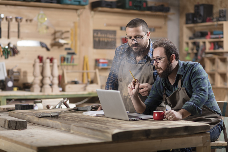 Two wood carpenters planning a business move. 