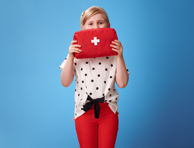 A girl holding a first aid kit.