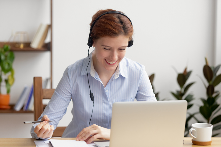 Woman with a headset in front of laptop.