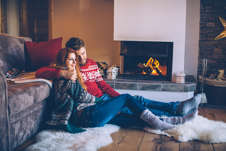 Couple sitting near their fireplace. 