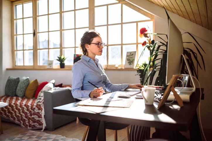 Women taking notes while working on the computer.