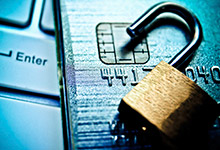 An open padlock, credit card and a laptop. 