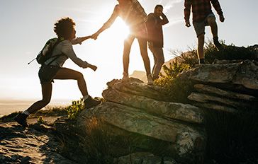 Group of people climbing up a hill. 